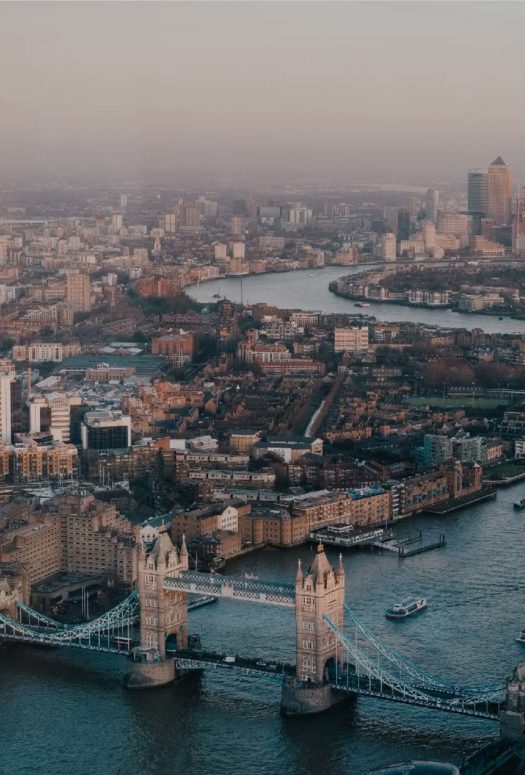 Aerial view of the River Thames winding through the city of London. City skyline with the Tower Bridge in the forefront.