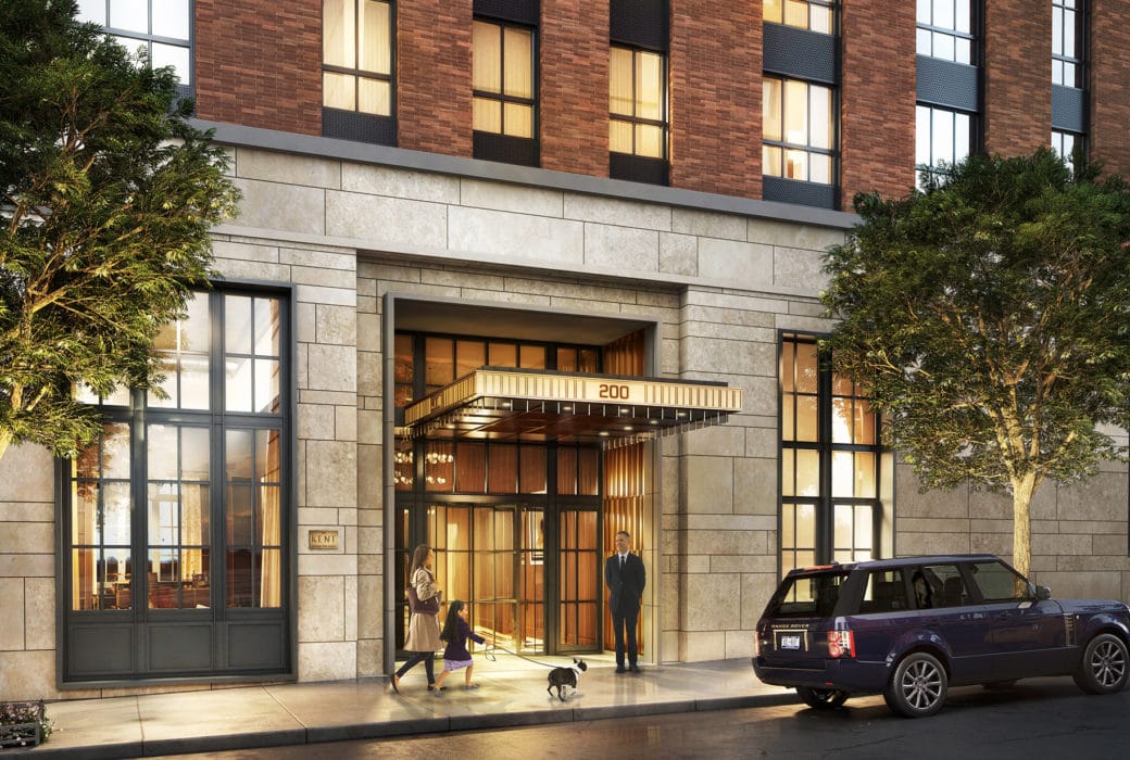 Exterior view of entrance to The Kent Condos in New York. Stone to brick exterior walls, double doors with canopy & doorman.