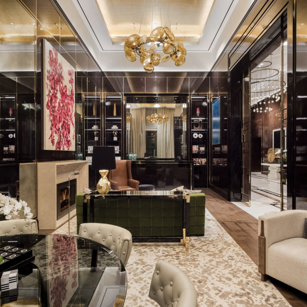 The Kent luxury condominiums in New York City. A room with black walls, built in shelves, and seating by a fireplace.