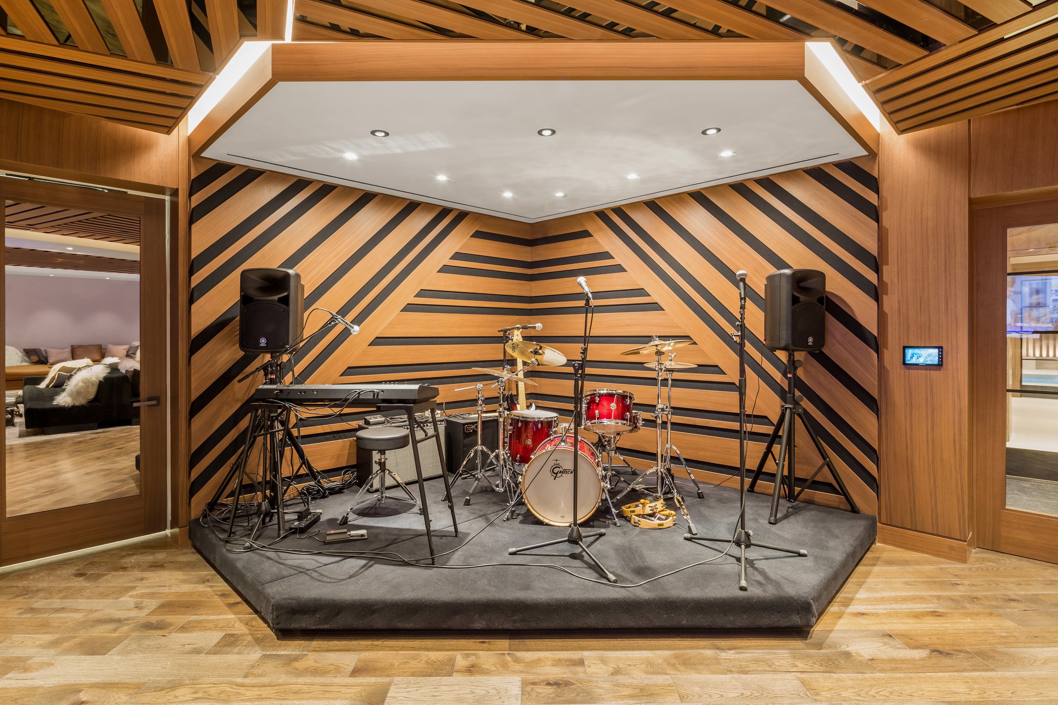 Music room at The Kent luxury condos in New York City. Small stage with instruments and wood backdrop with black lines.