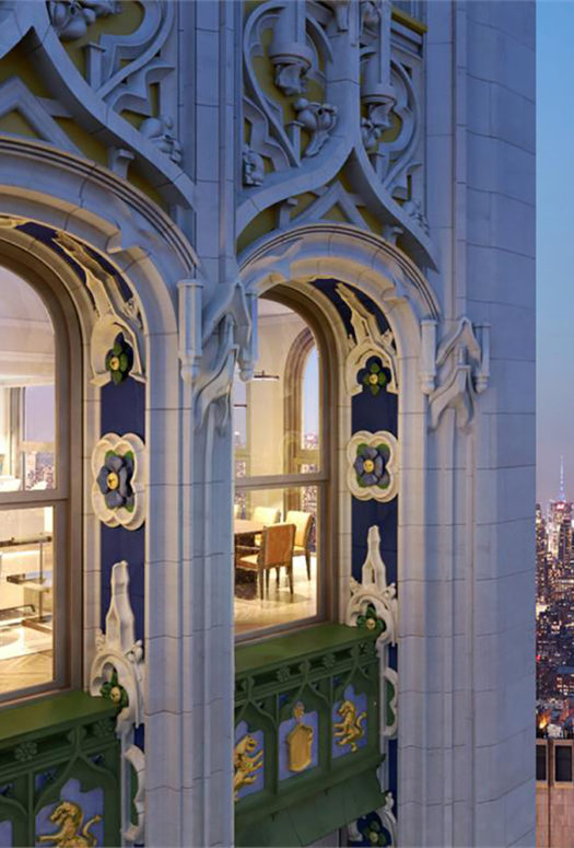 Exterior of the Woolworth Tower residences in New York. Gothic design and arched windows overlooking city skyline at night.