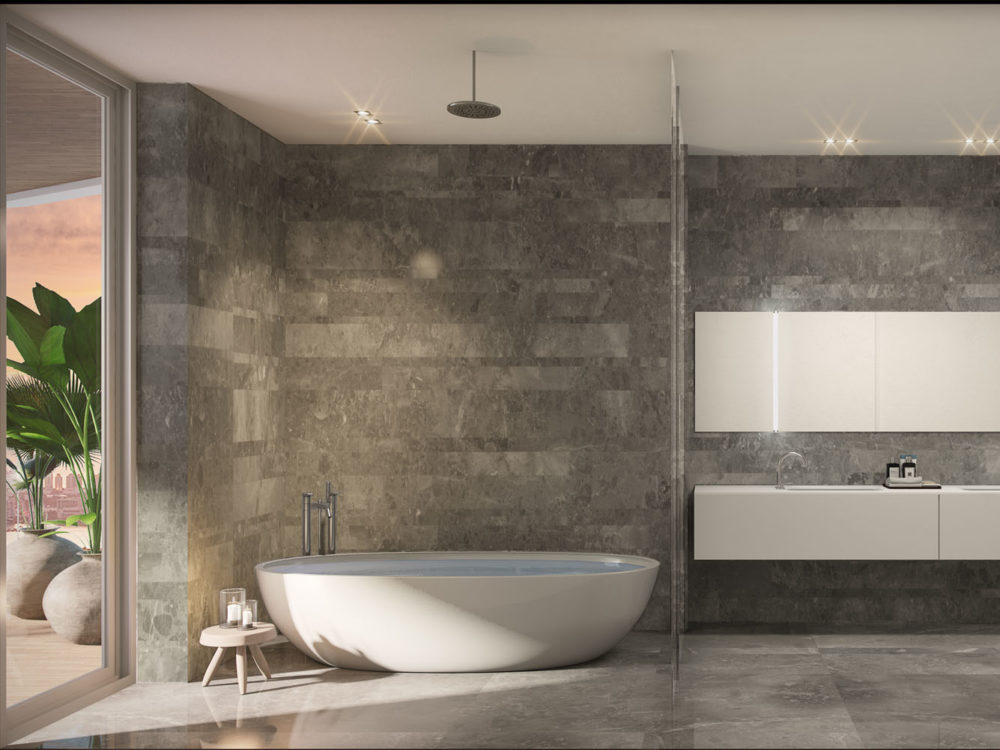 Interior view of Monaco Yacht Club residence bathroom with stoned walls and classy white tub. Open window view of the ocean.