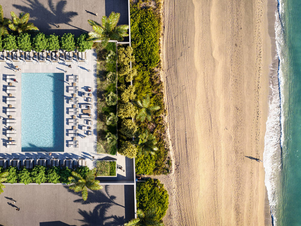 Exterior aerial view of 2000 Ocean condominium with an ocean front pool with palm trees located in Hallandale Beach, Florida.