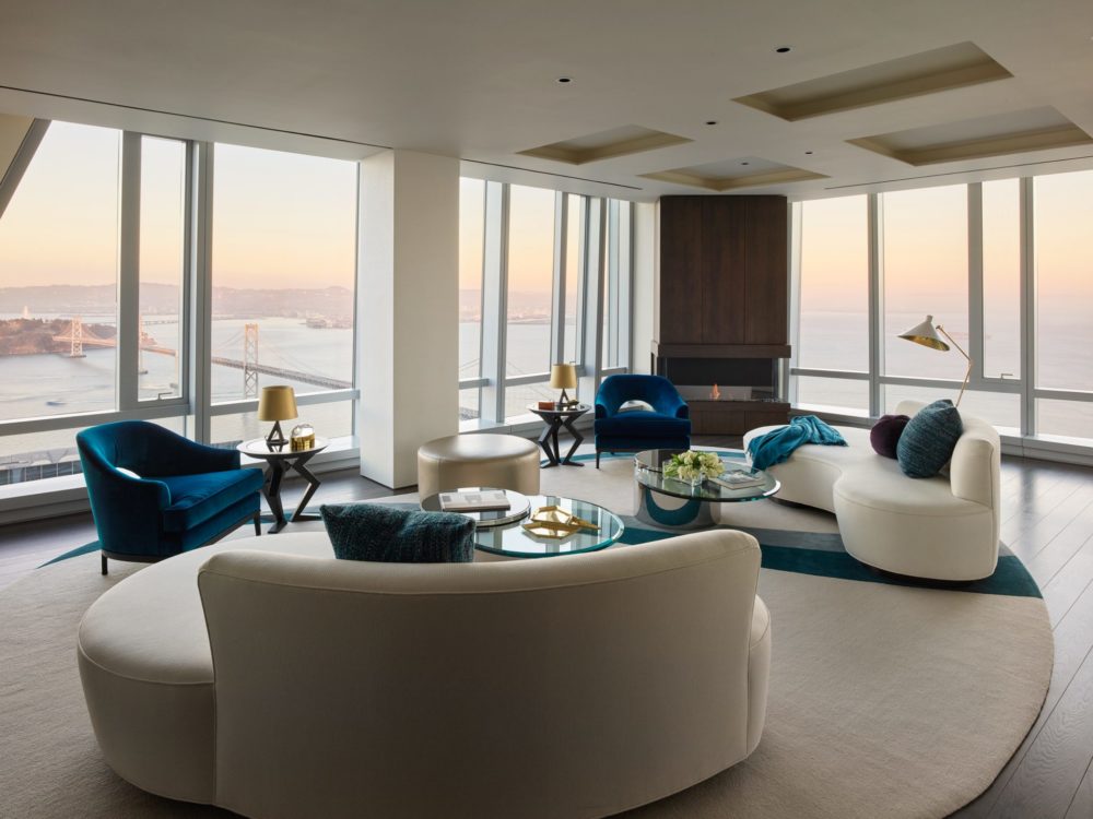 Interior view of 181 Fremont residence living room with skyline view of San Francisco. Includes couches and chairs to sit.