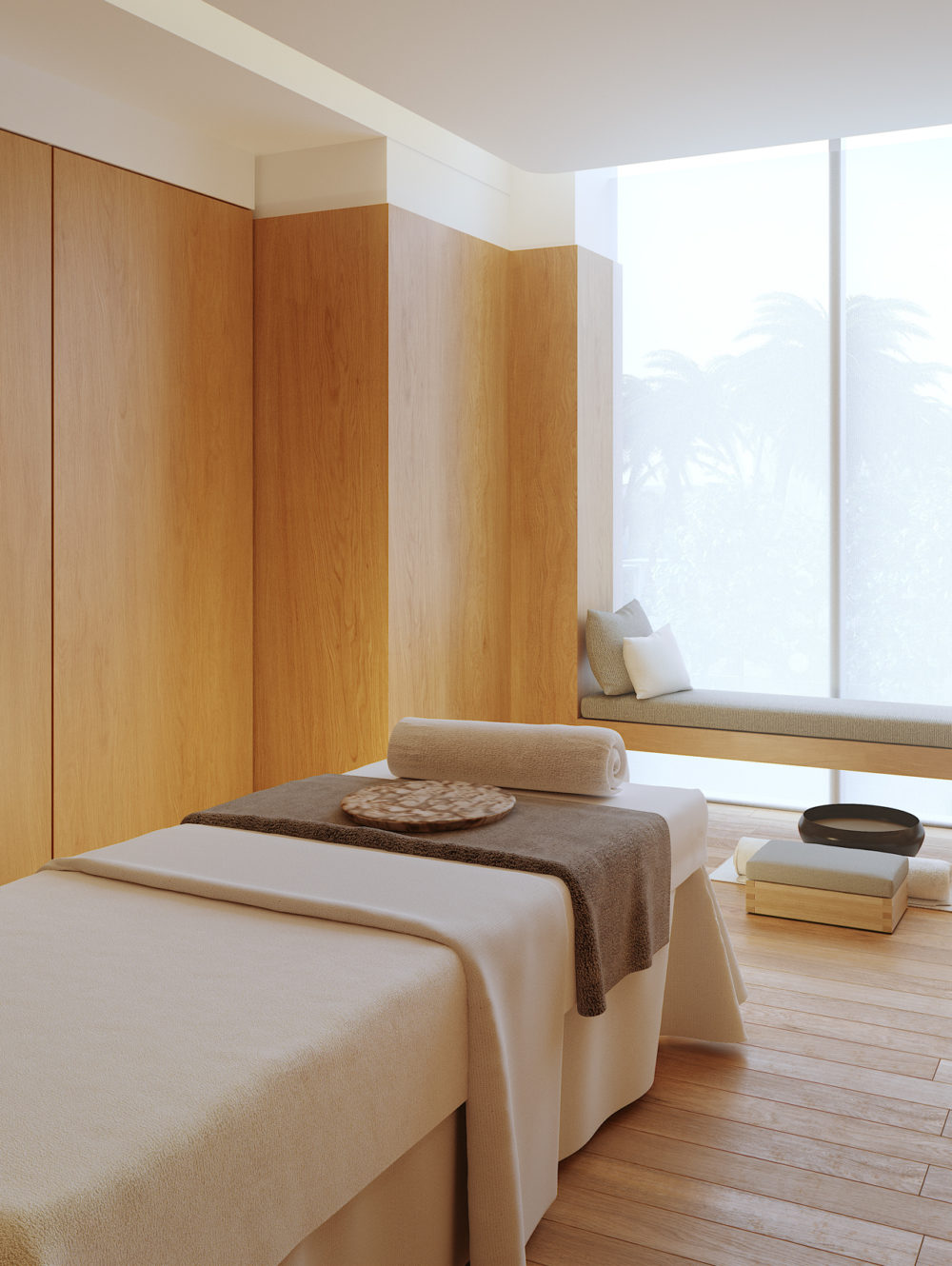 Interior view of Missoni Baia residence spa with window view of ocean. Has a massage table and wood floors and wall.