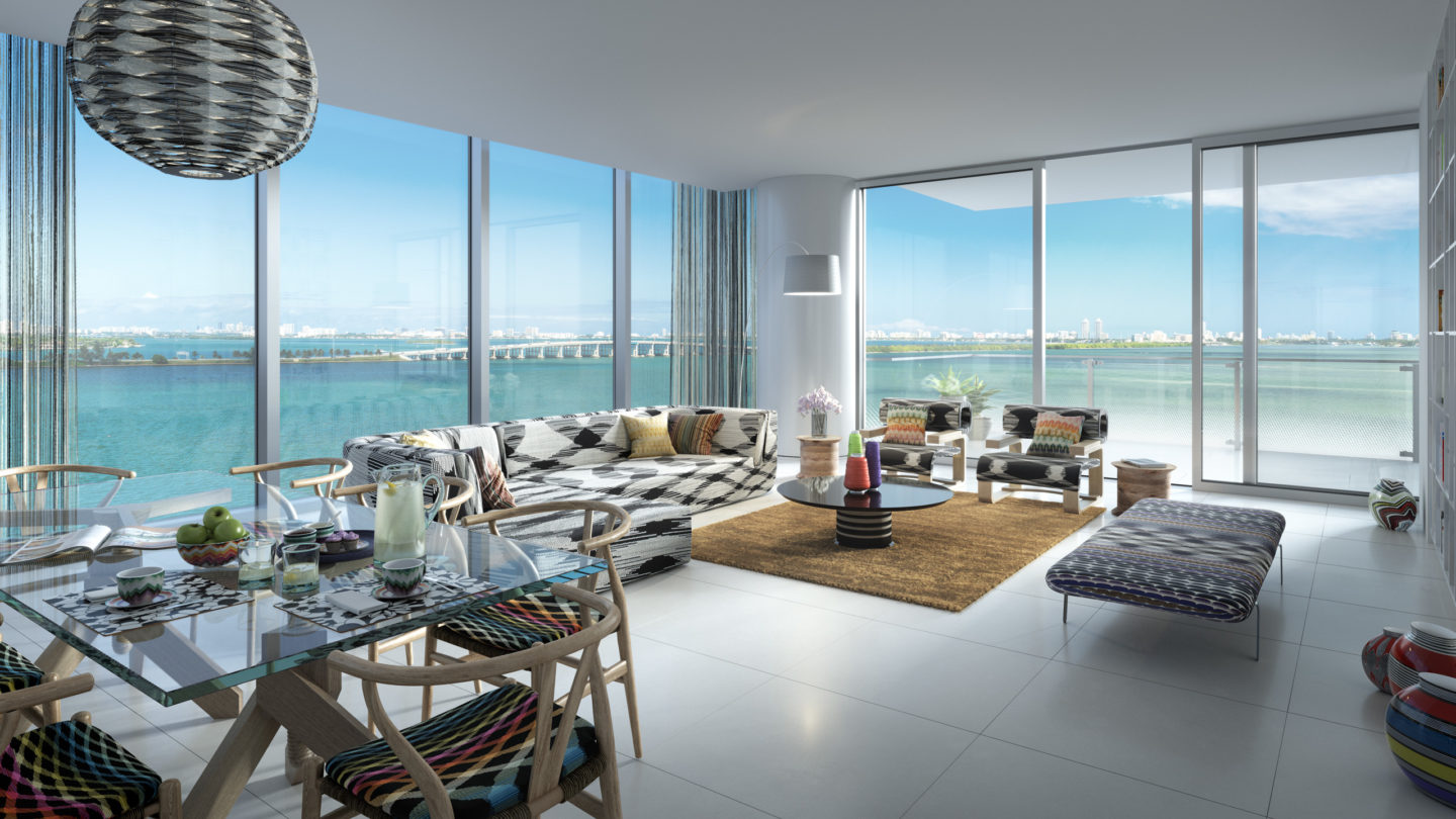 Interior view of Missoni Baia residence living room with oceanfront window view. Has glossy white floors and balcony.