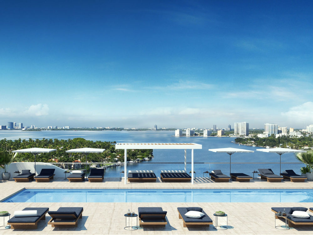 Exterior view of Monaco Yacht Club residence pool and lounge area with oceanfront view. Has cabanas and lounge chairs.