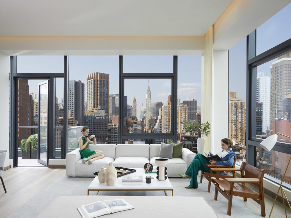 Interior view of 88 & 90 Lexington residence penthouse living room with skyline view of New York City.