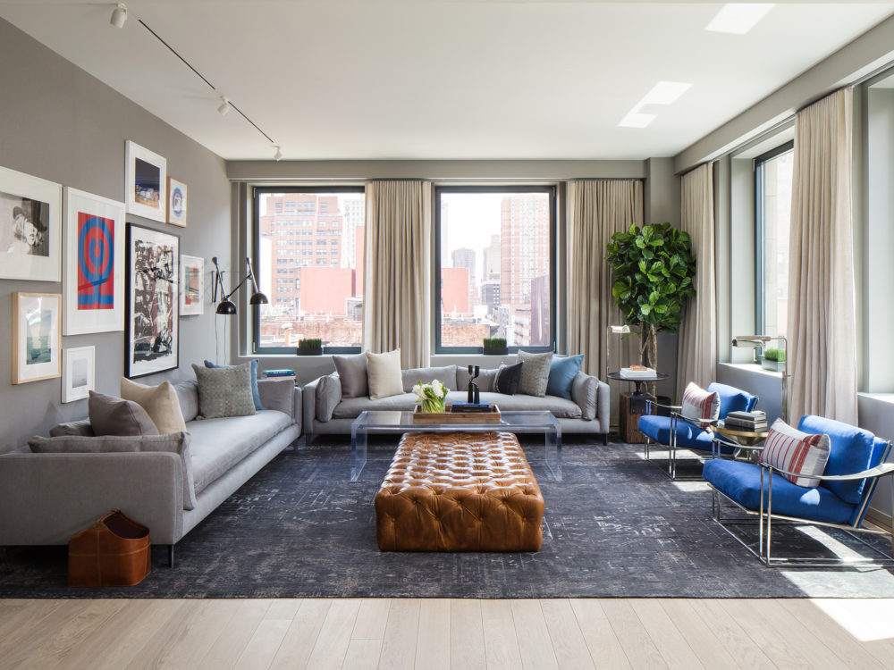 Interior view of 88 & 90 Lexington residence living room in New York City. Has blue chairs and grey couches.