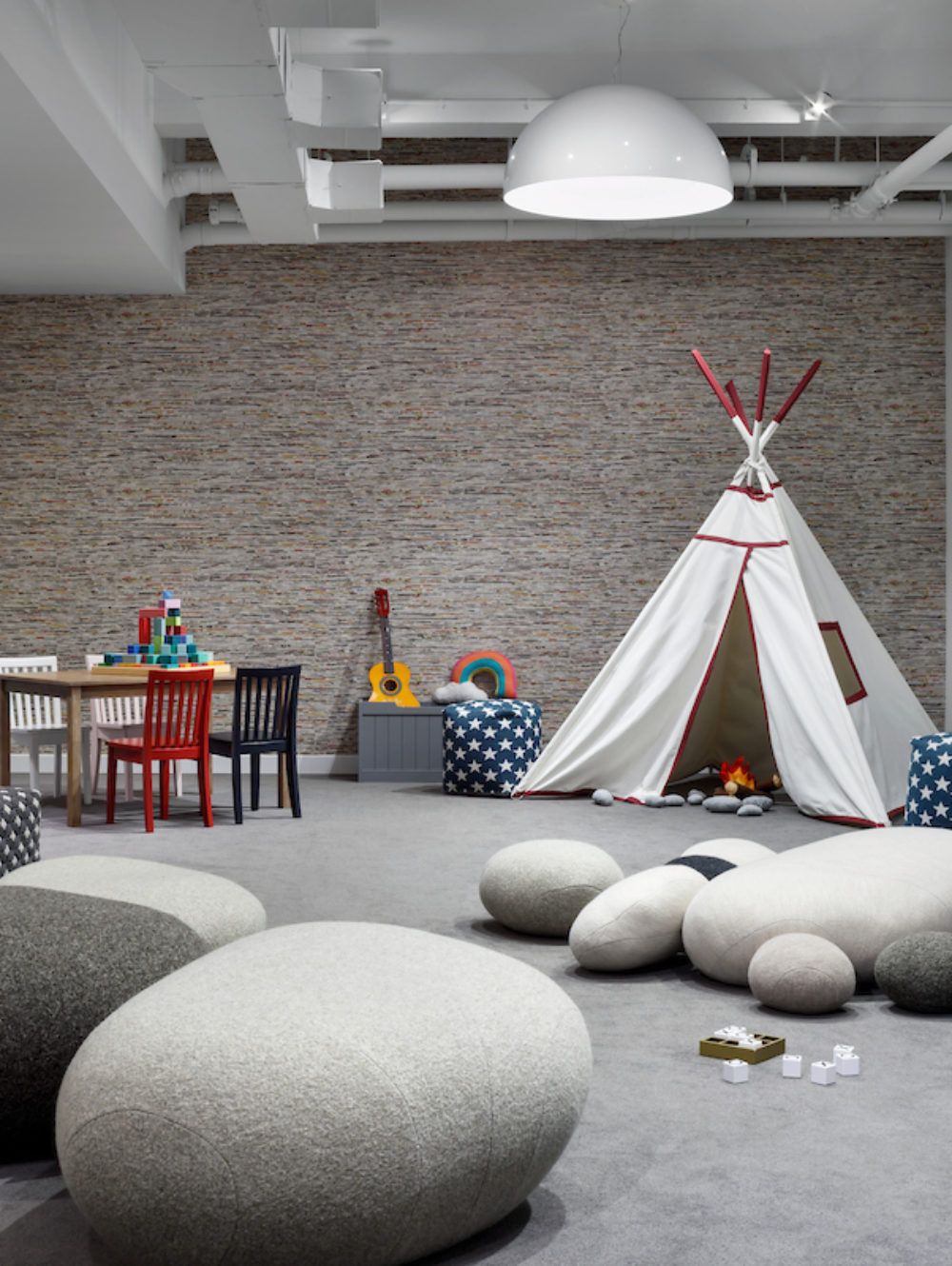 Interior view of 88 & 90 Lexington residence kids playroom in New York City. Has white tent, grey carpet floors and chairs.