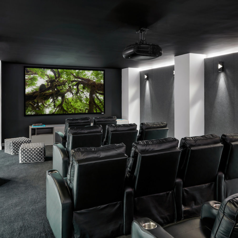 Interior view of 88 & 90 Lexington residence theater in New York City. Has screen and black, leather chairs.