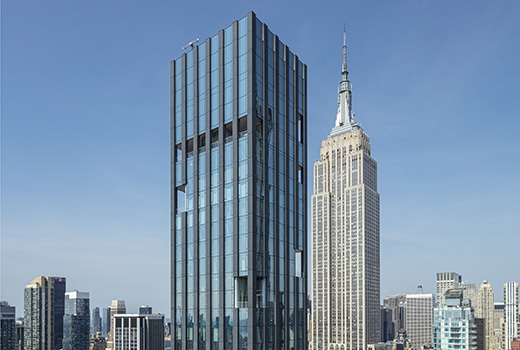 Exterior aerial view of 277 Fifth Avenue condominiums. Includes view of New York City and detailed architectural building.