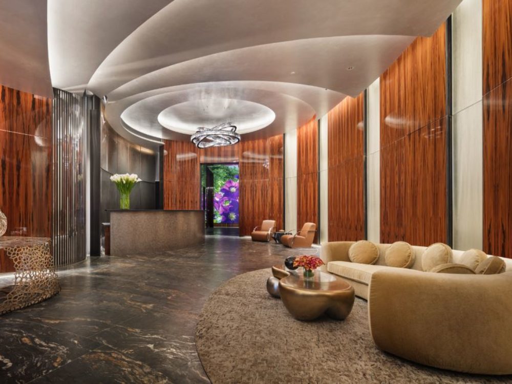 Interior view of lobby inside 35 Hudson Yards condominiums in NYC. Includes long couches and detailed walls and floor.