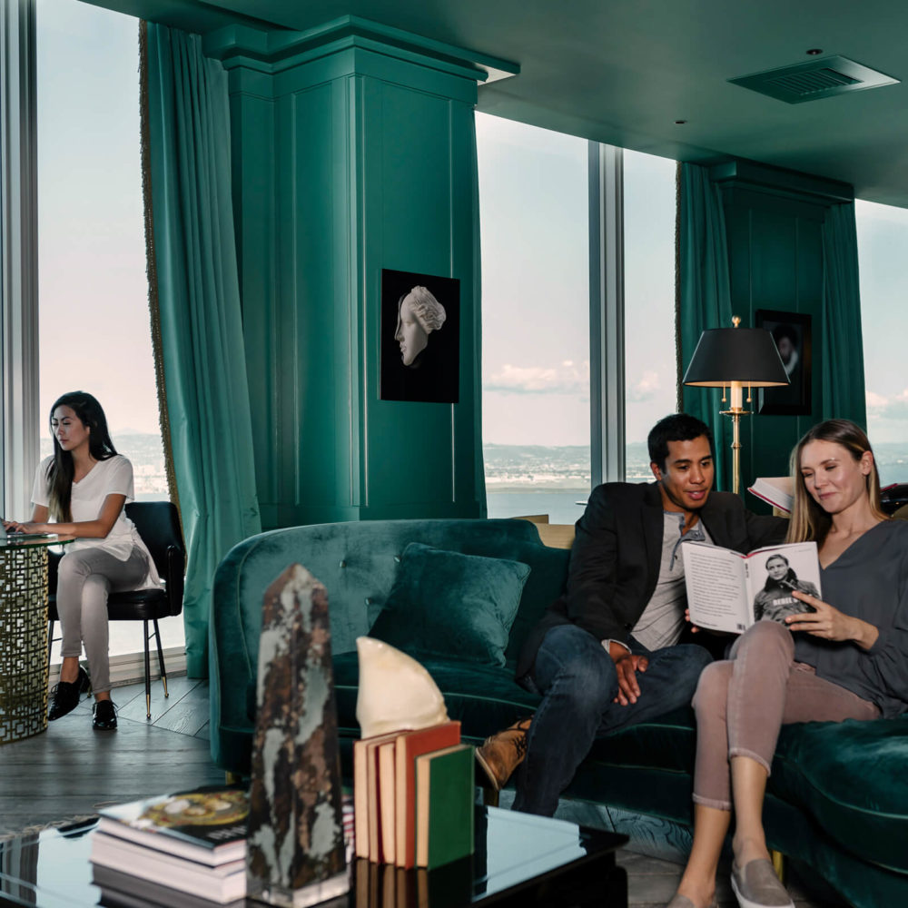 Conference room at The Harrison condominiums in San Francisco. Teal walls and furniture and large windows with city views.