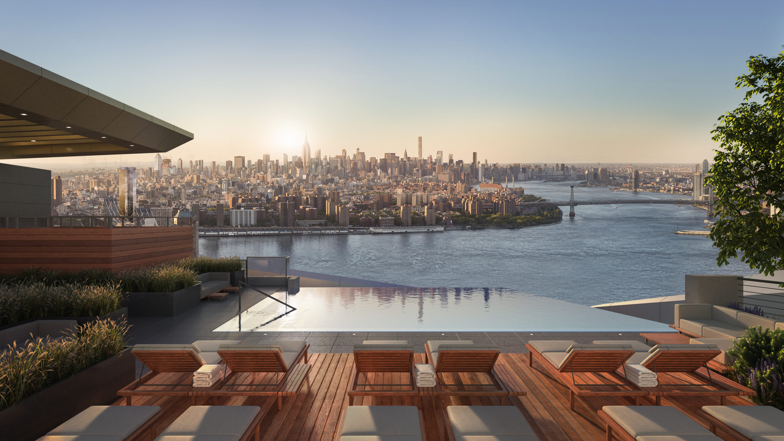 Exterior view of Brooklyn Point condominiums outdoor pool with river view and red lounging chairs in New York City.