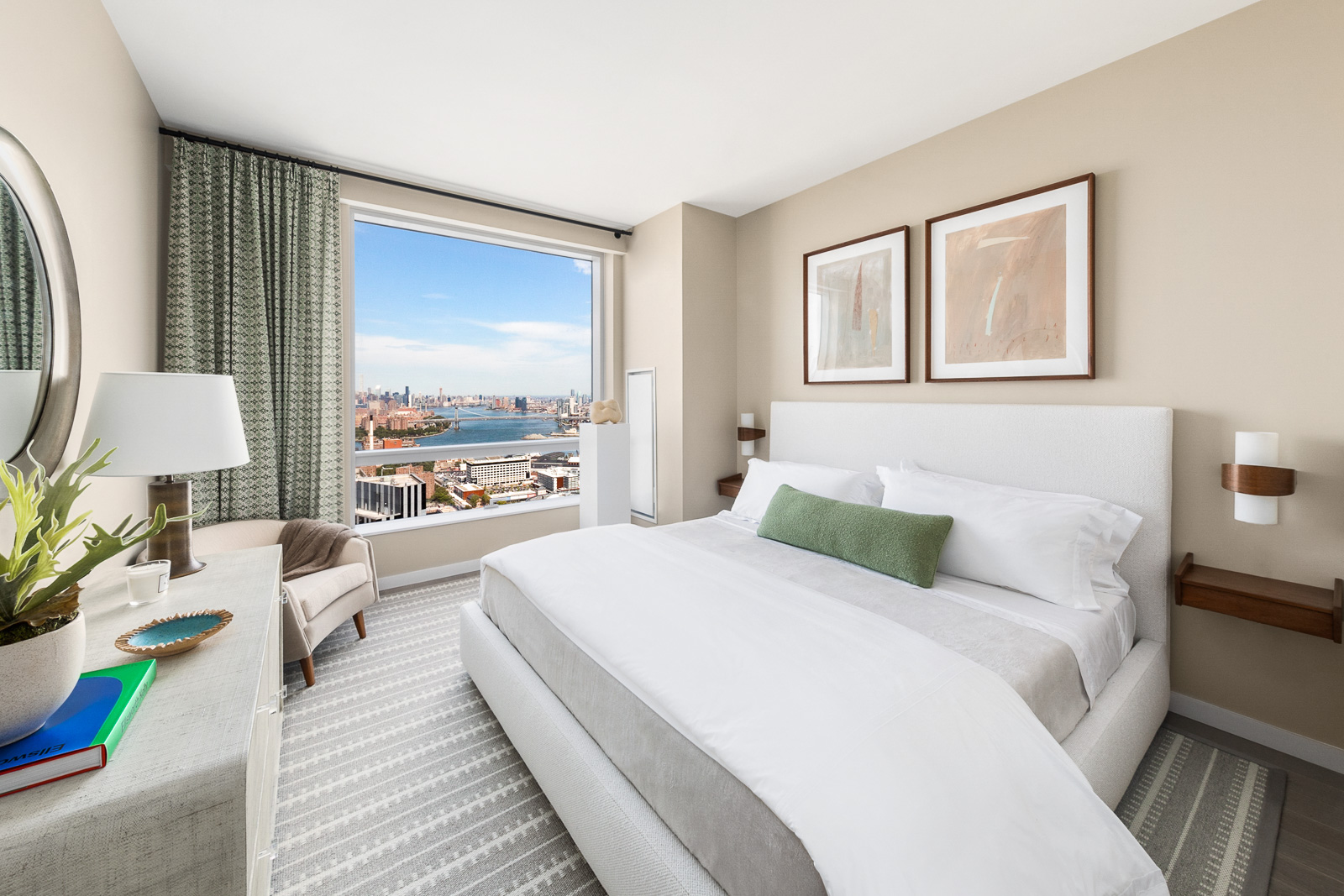 Interior view of Brooklyn Point residence master bedroom with skyline window view. Has striped carpets and white bed.