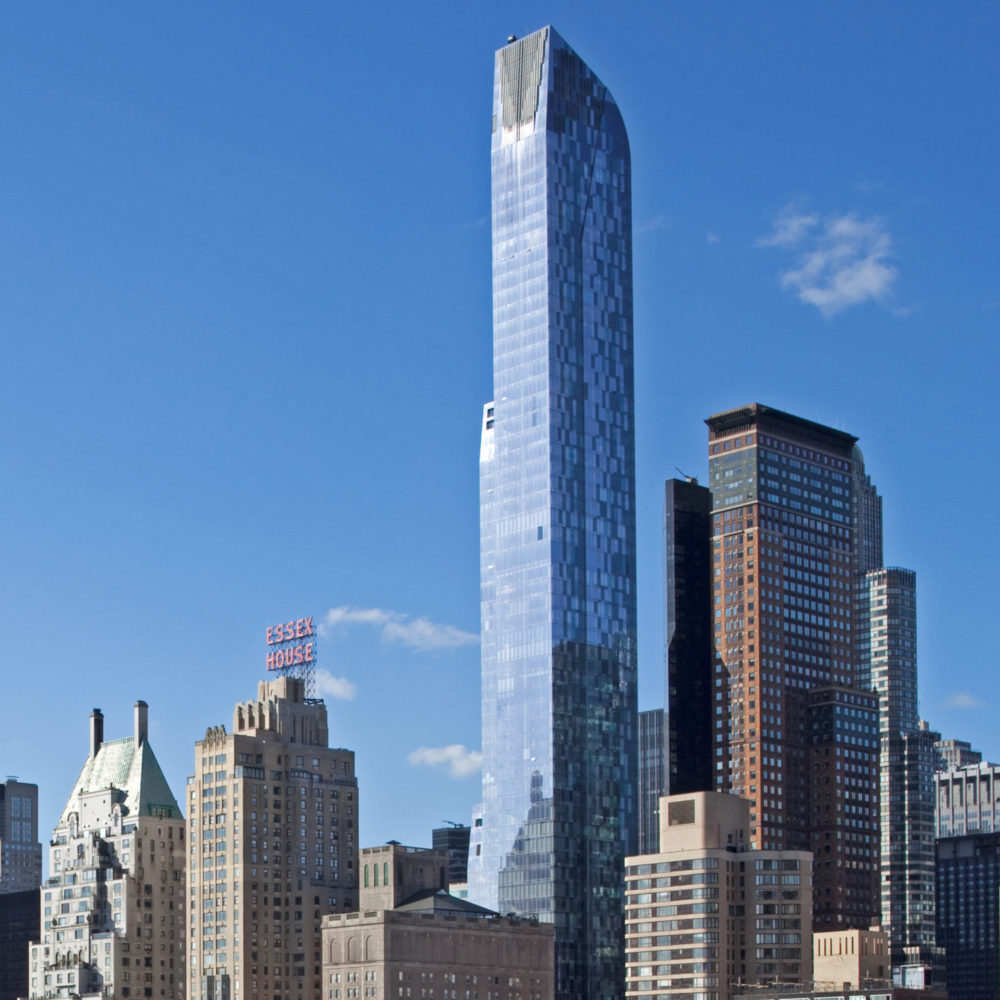 View of New York City high rises from Central Park. One 57 luxury condominiums in NYC is center building with blue skies.