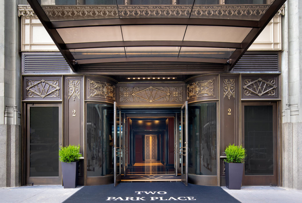 Main street entrance to the Woolworth Towers in New York. Open double doors and gold finished exterior with glass canopy.