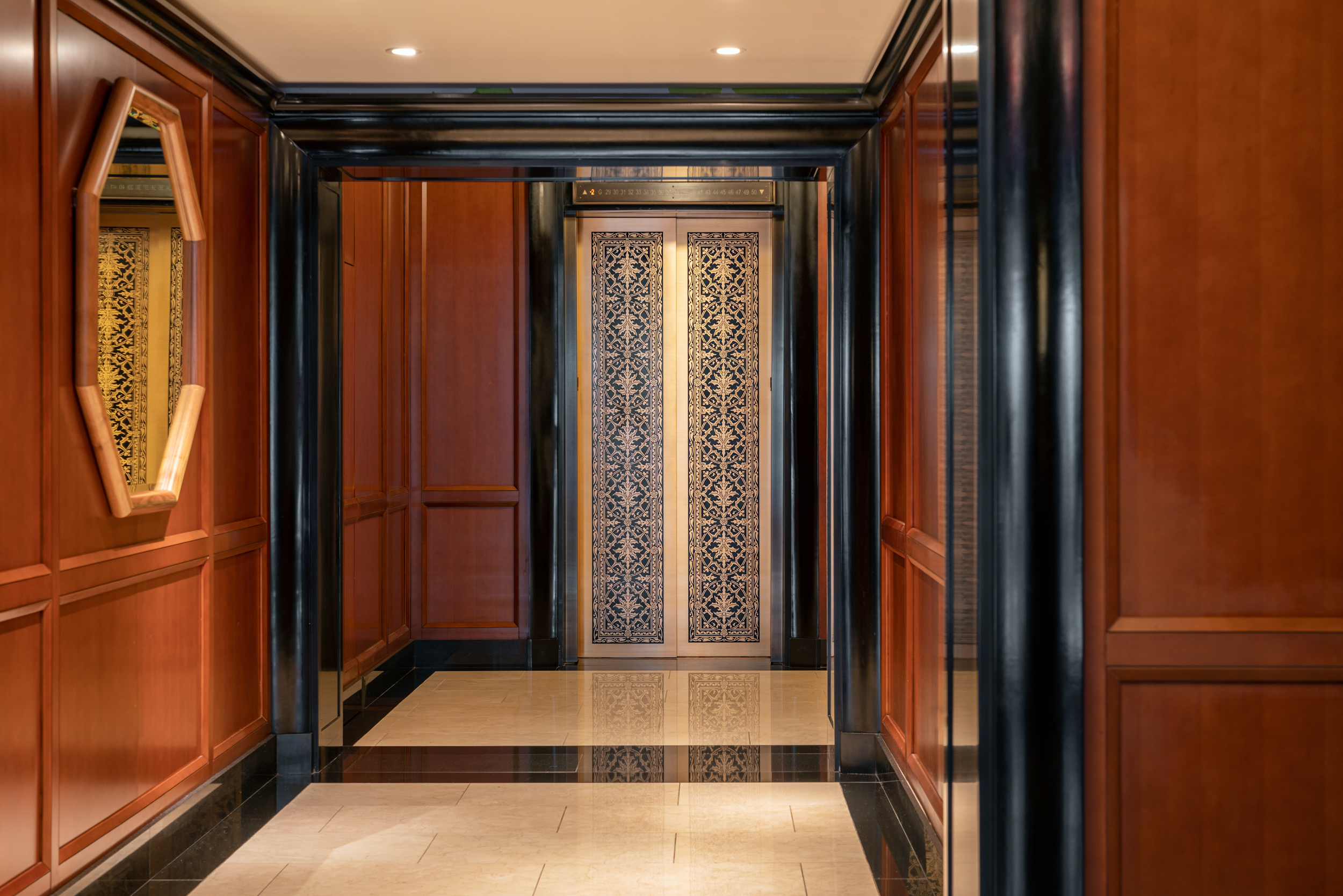 Elevator lobby at the Woolworth Tower condos in New York. Dark wood walls with black finishings and a gold elevator gate.