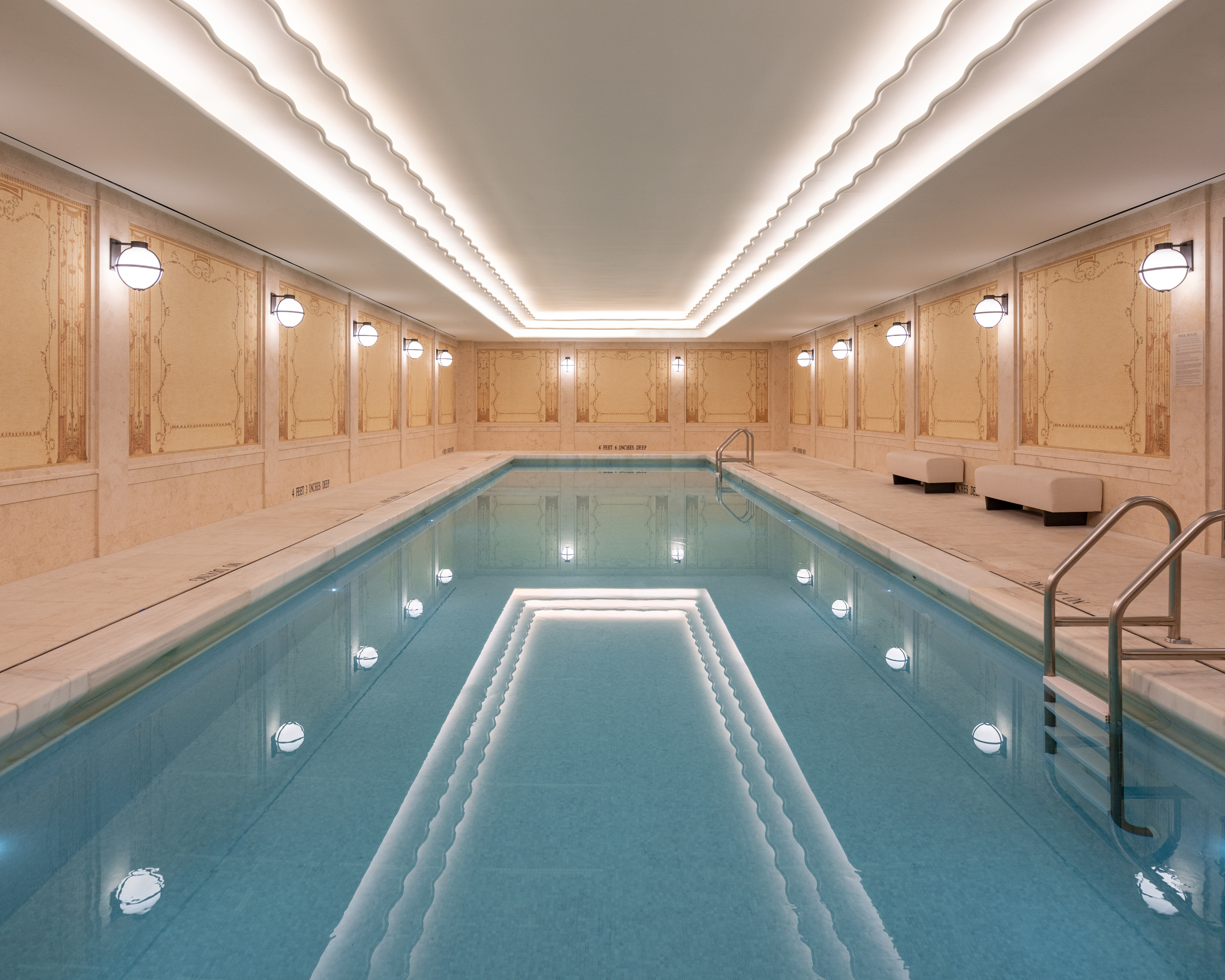 Underground 50-ft lap pool at the Woolworth Tower in New York. White ceiling with lights running the length of the pool.