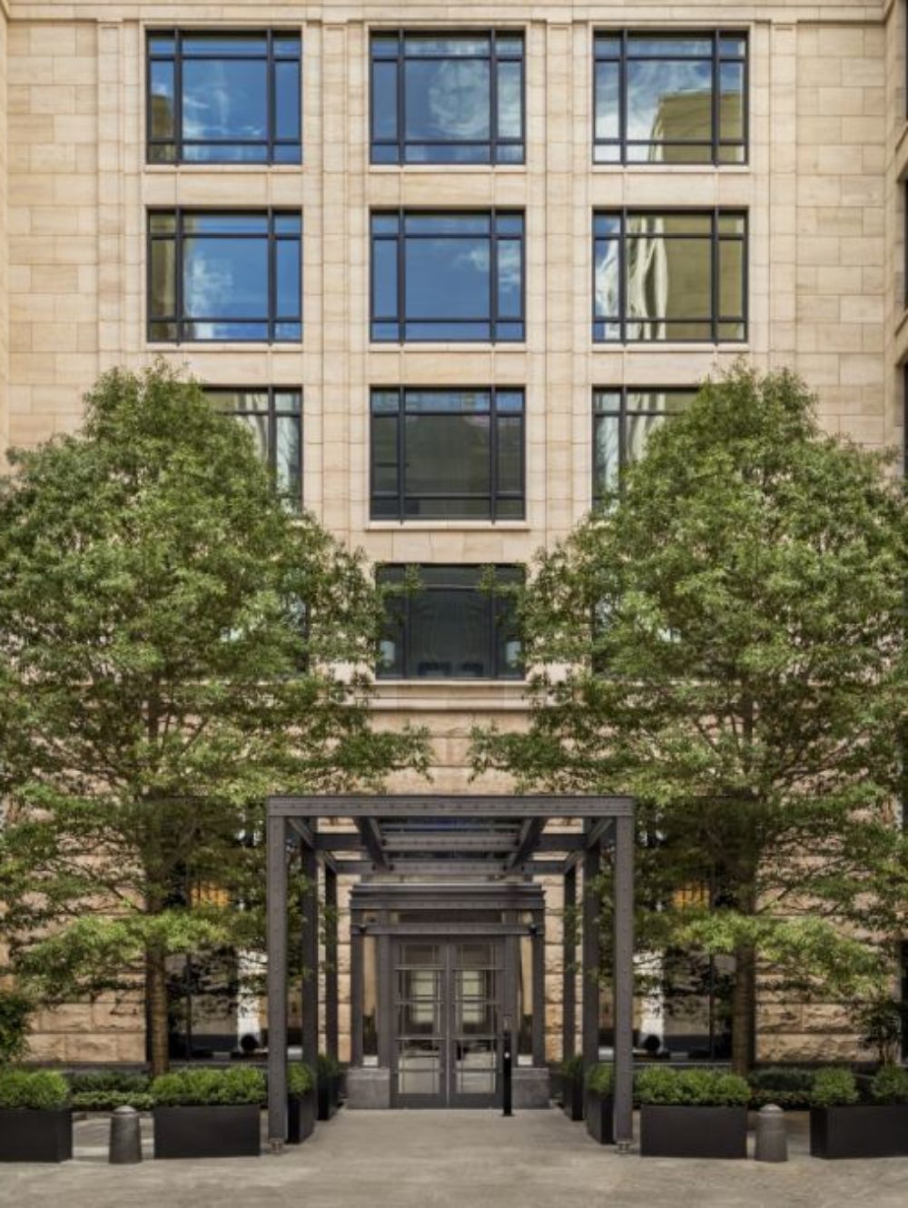 Exterior view of 70 Vestry condominiums entrance in New York City. Has symmetrical tree formation of both side of entrance.