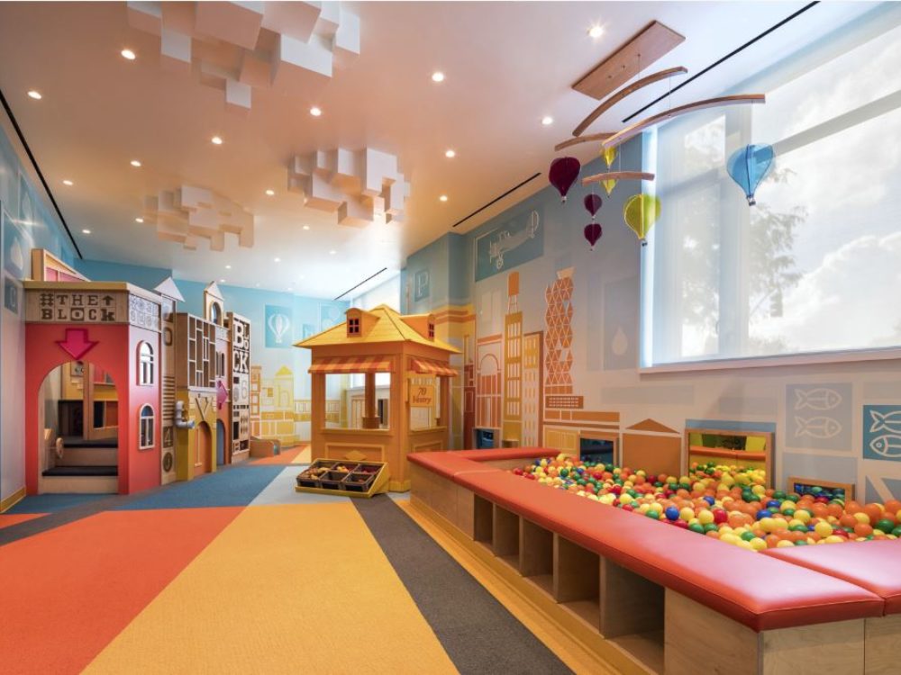 Interior view of 70 Vestry residence kids room in New York City. Has colorful floors, tables for play and shelves.