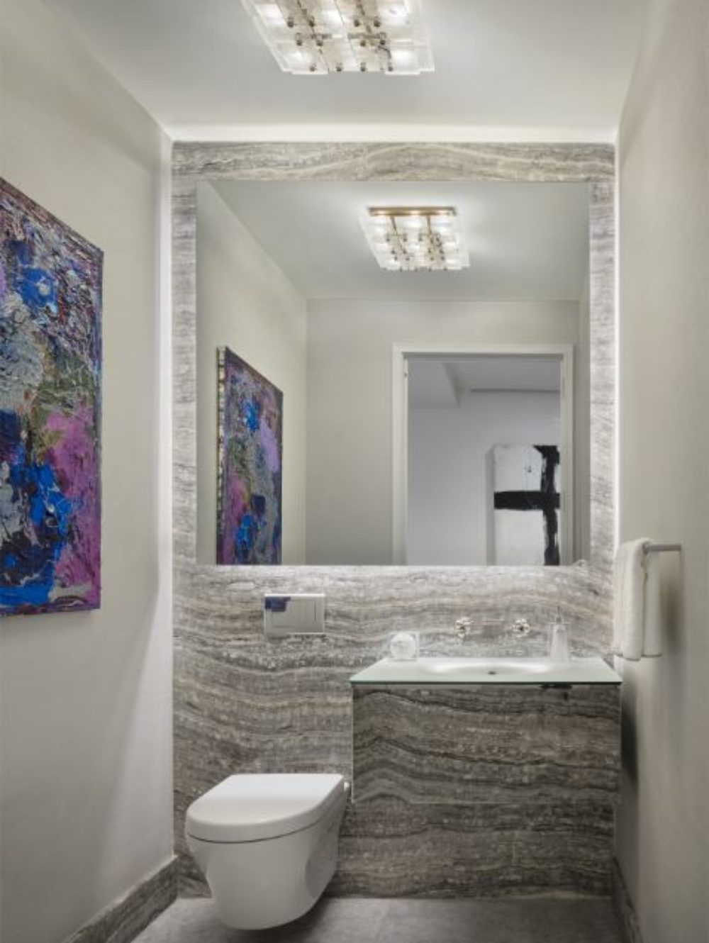 Interior view of 35 Hudson Yards residence powder room in NYC. Includes white walls and wood mirror and sink area.