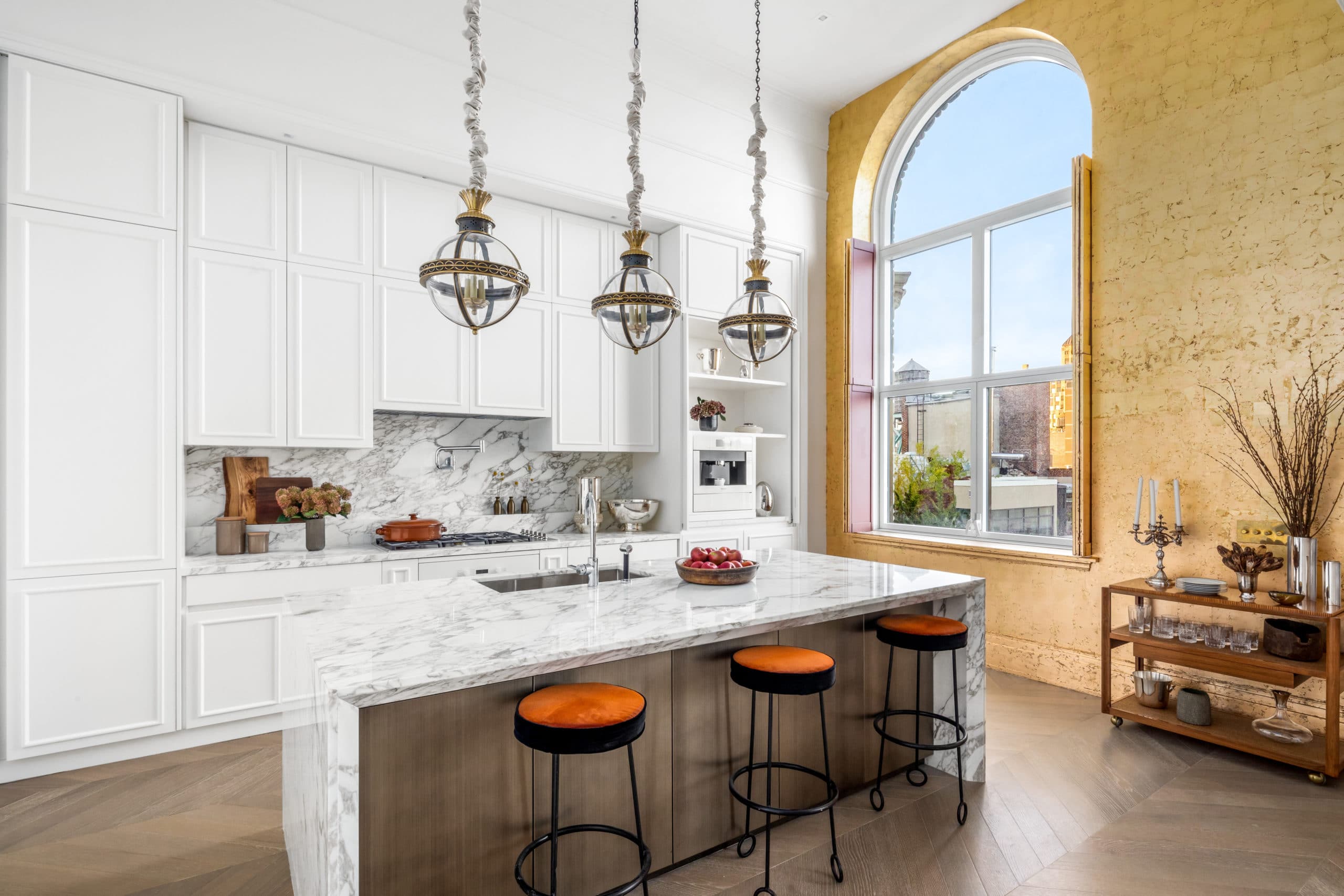 Interior of a kitchen in 108 Leonard with white walls accented with a yellow wall and a window overlooking New York City.