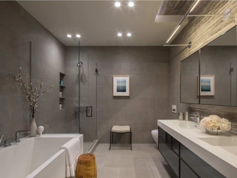 Interior view of 88 & 90 Lexington residence bathroom in New York City. Has a white bathtub, brown walls and sink area.
