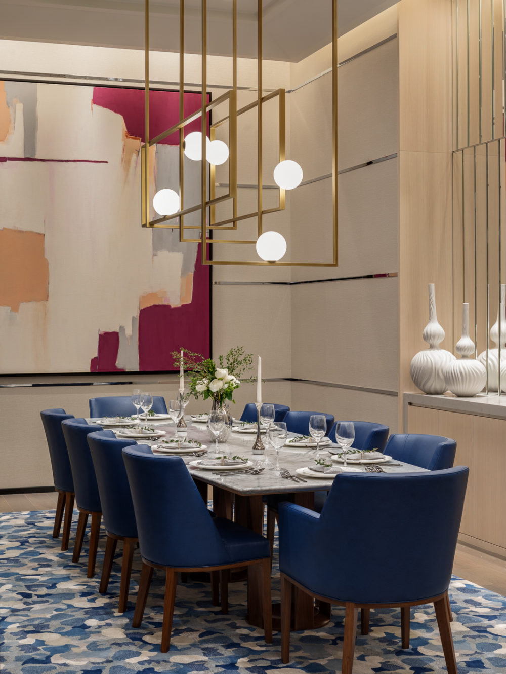 Interior view of 277 Fifth Avenue residence private dining room in NYC. Includes table with blue chairs and lighting fixture.