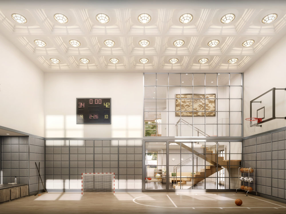 Full sports court with raised ceilings, a basketball hoop, scoreboard & benches at The Belnord luxury apartments in New York.