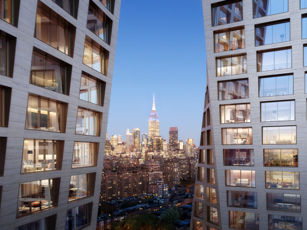 Exterior view of The Xi condominium towers in New York City with the Empire State Building visible in the skyline background.