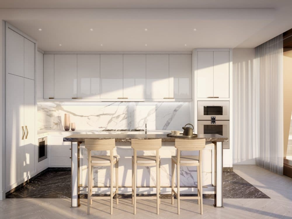 A kitchen at The Xi condos in New York. White walls and cabinets, a small island countertop and floor-to-ceiling windows.