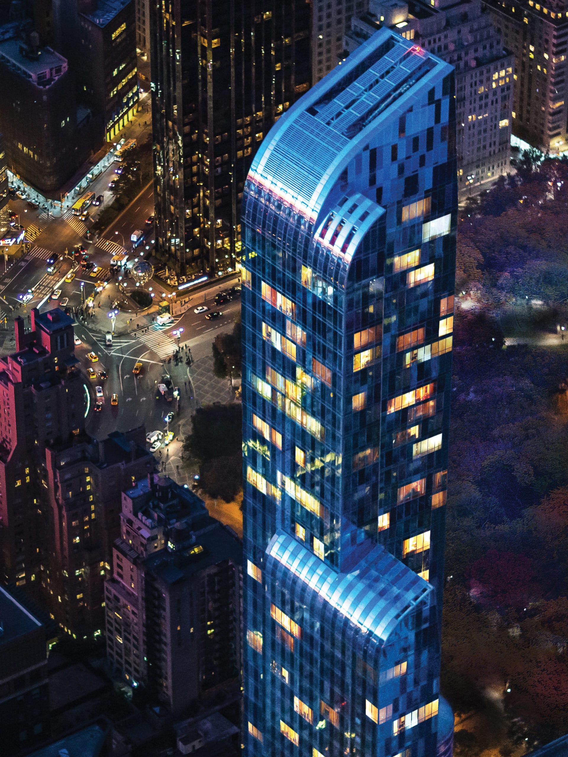 Aerial view of One57 luxury condos in Manhattan, NY. Night time looking down at the tower with city lights in the background.