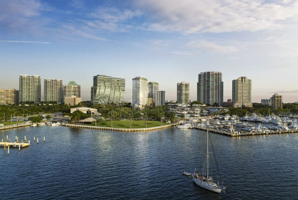Aerial view of Biscayne Bay marina with high rises on the coastline, including Mr C. Residences in Coconut Grove, Miami.