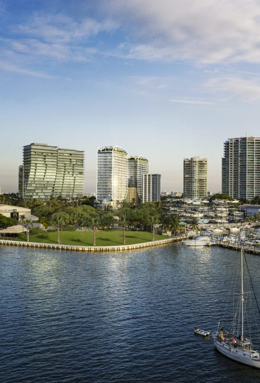 Aerial view of Biscayne Bay marina with high rises on the coastline, including Mr C. Residences in Coconut Grove, Miami.
