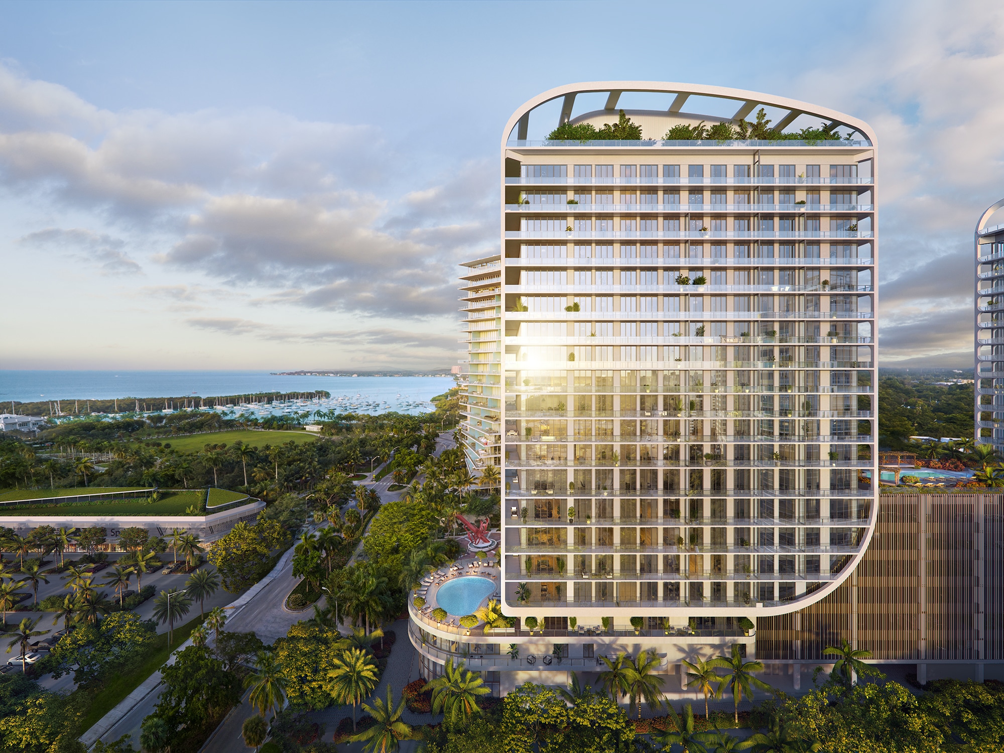 Side view of Mr. C Residences on the Miami waterfront. North facade of luxury condominiums with a marina in the background.