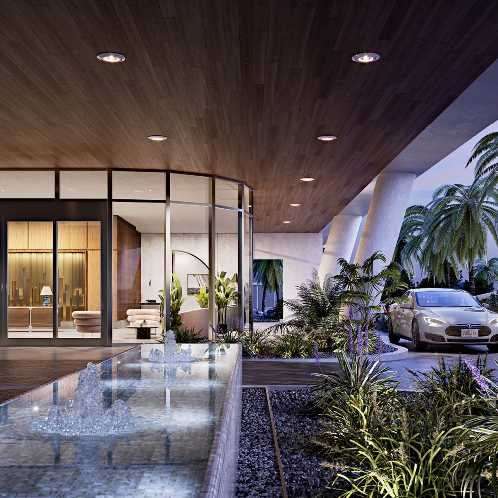 Front entrance and driveway at Mr. C Residences in Miami. Water fountain and ferns near floor-to-ceiling windows of lobby.