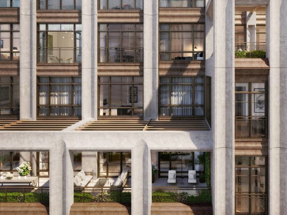 Exterior view of facade designed 25 Park Row condominiums in NYC. Has a view of interior residence spaces with white pillars.