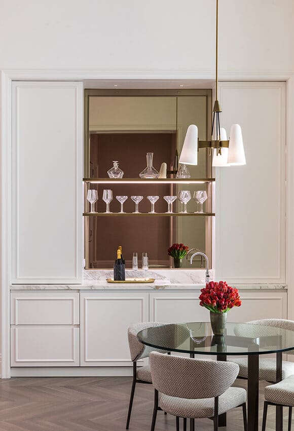 Interior at 108 Leonard luxury condo in New York. White walls with built-in wet bar, upper shelves and a small glass table.