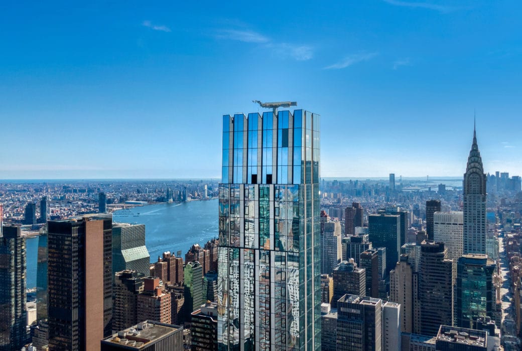 Birdseye view of The Centrale in New York City. A glass facade tower with art-deco flourishes centered in the city skyline.