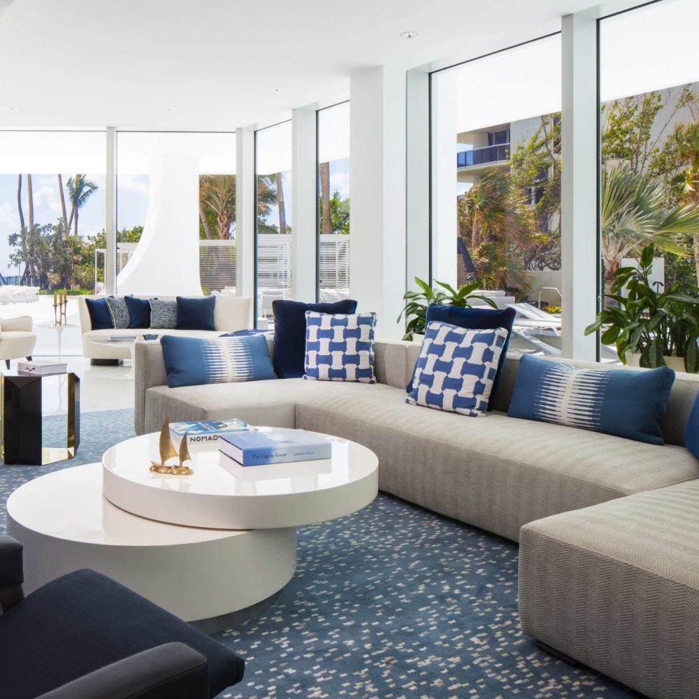 Interior view of Jade Signature residence entertainment lounge. Includes oceanfront window view and lounging furniture.