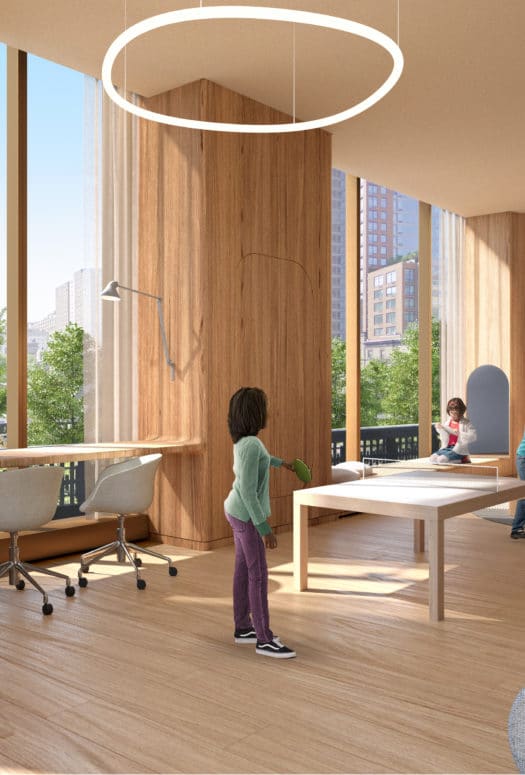 The playroom at The Xi luxury condos in NYC. Large room with chairs, couches, toys, and large windows with views.
