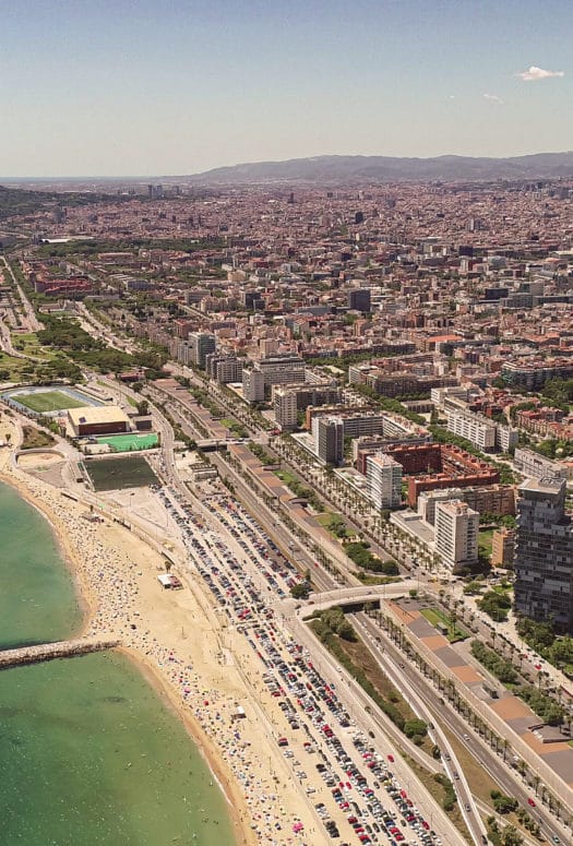 Aerial view of oceanfront properties in Barcelona. Has beachfront open space and tall buildings.