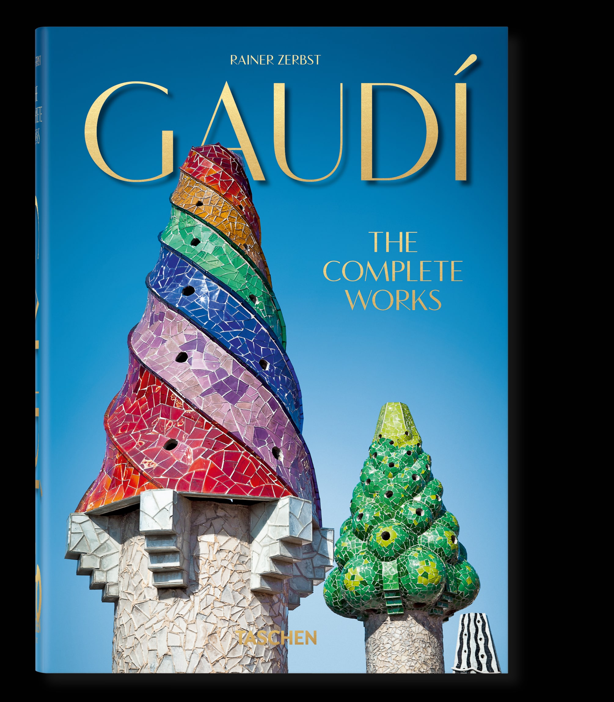 Book cover of Gaudi: The Complete Works. Blue background with cone shaped structures with colorful top halves.