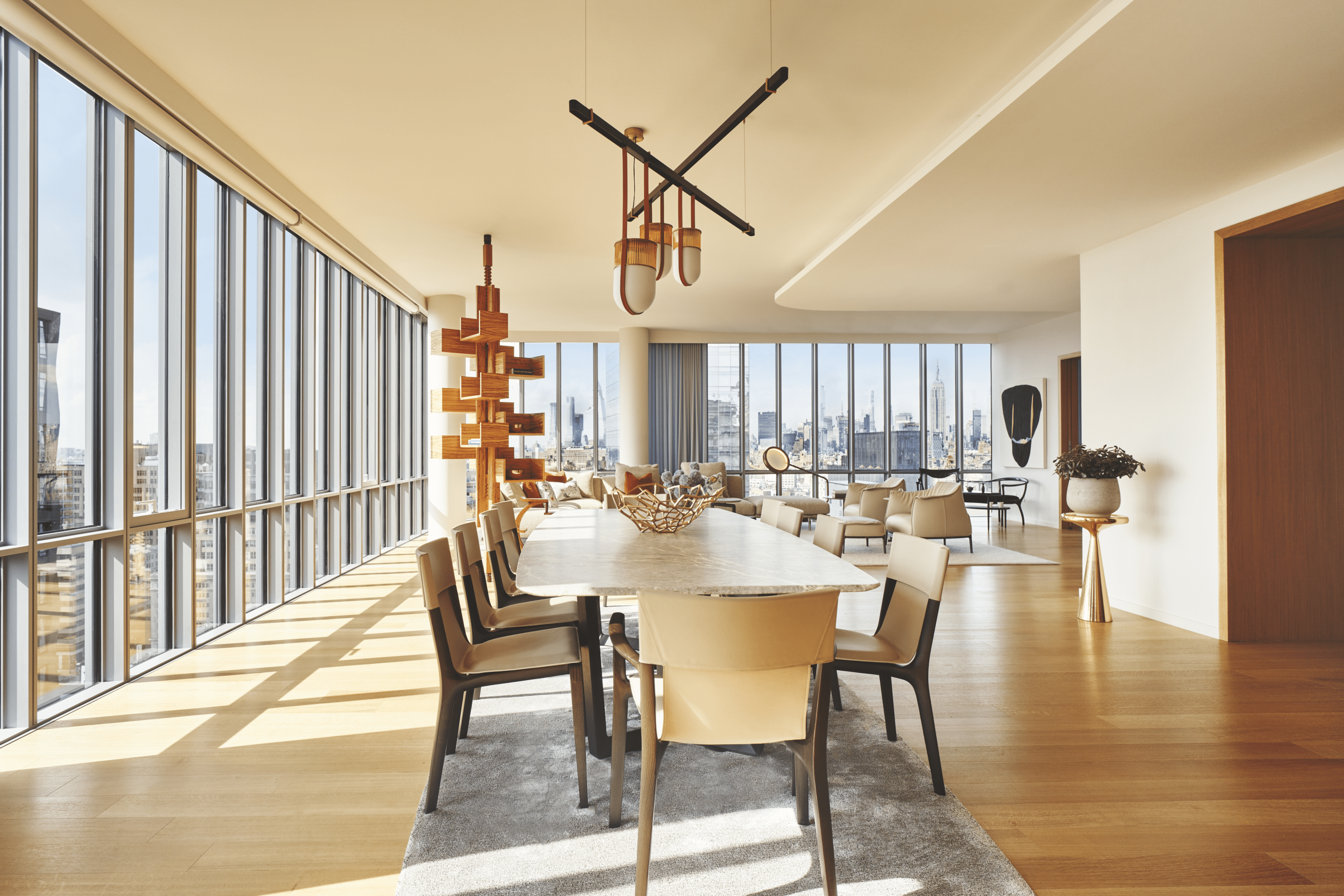 Interior view of 565 Broome condominium conference room with window view of New York City. Has wood floors and furniture.