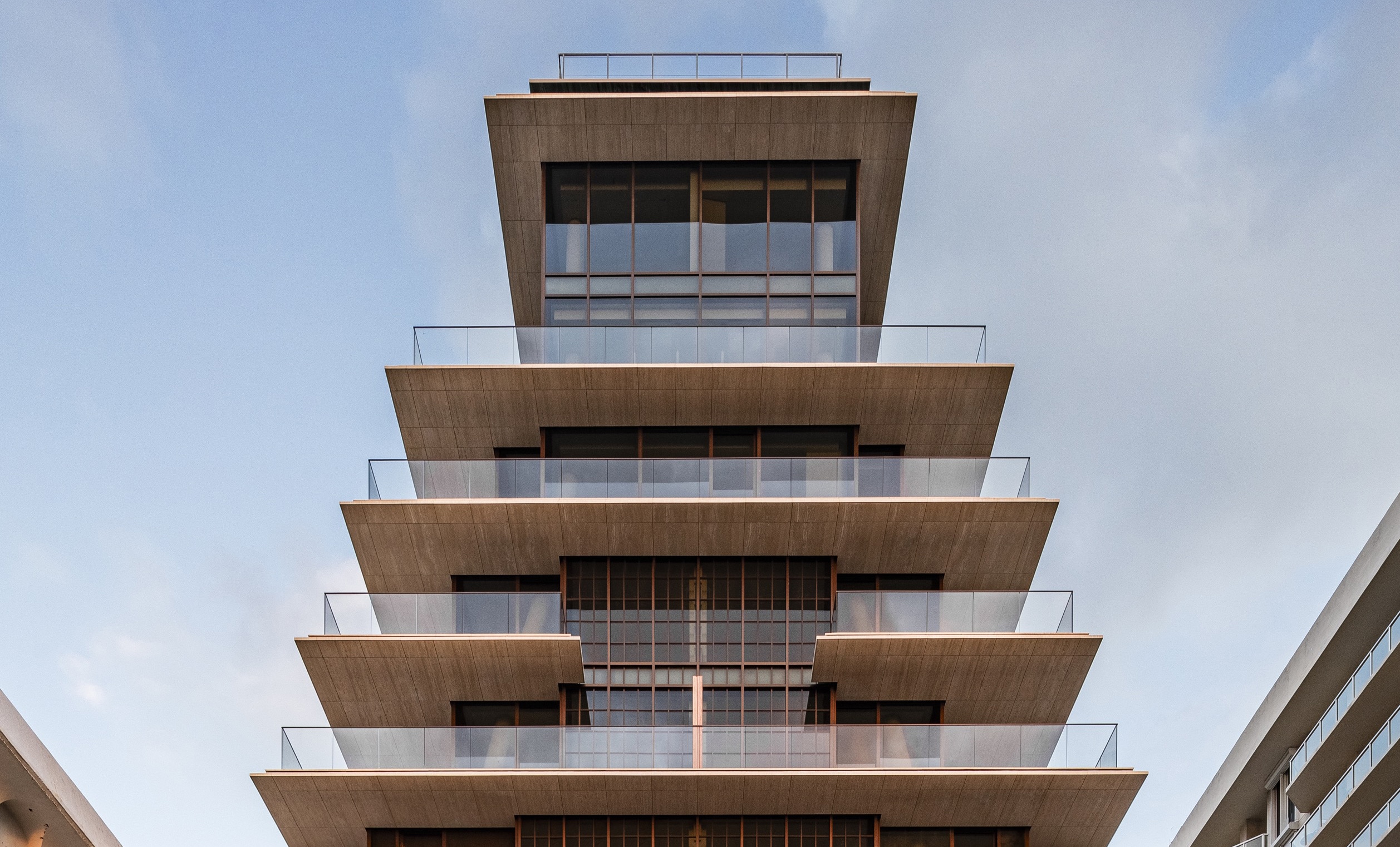 Exterior view of the penthouse at Arte Surfside luxury condos in Miami with wrap around balconies and dark exterior walls.